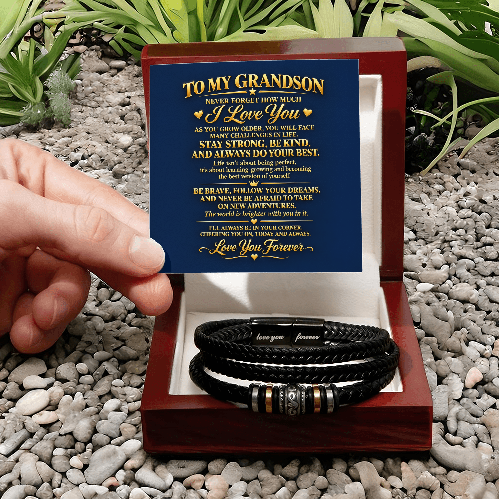 Black braided bracelet in an open mahogany-style gift box on pebbles, with a “To My Grandson” message card.
