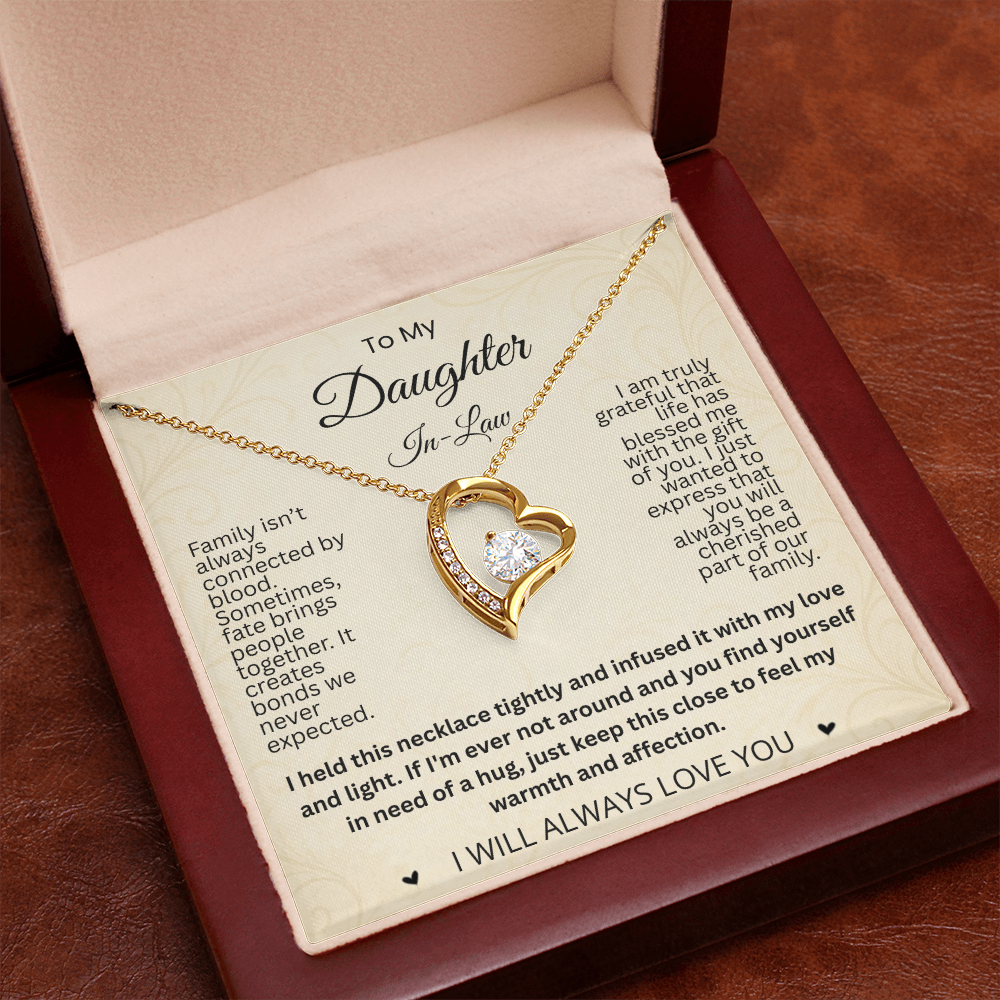 Close-up of a gold-tone heart necklace and daughter-in-law card in an open reddish-brown gift box.