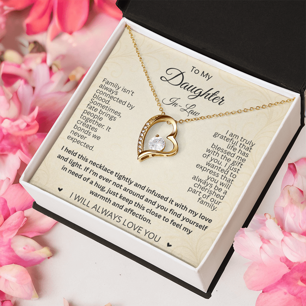 Gold-tone heart necklace and daughter-in-law card in a black and white gift box surrounded by pink petals.